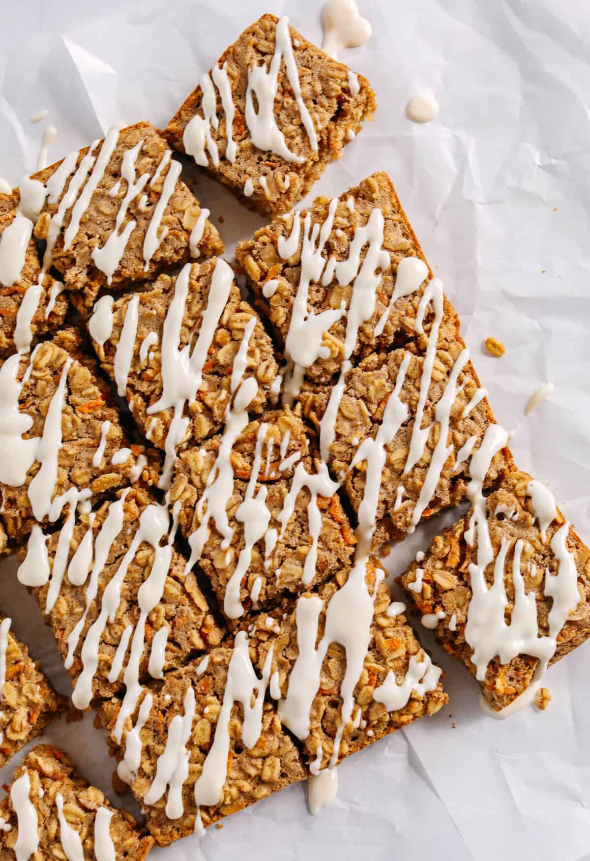 These EASY Healthy Carrot Cake Oatmeal Breakfast Bars make a quick on-the-go breakfast, snack or wholesome dessert! Made with zero refined sugar and drizzled with a delicious maple cream cheese frosting.