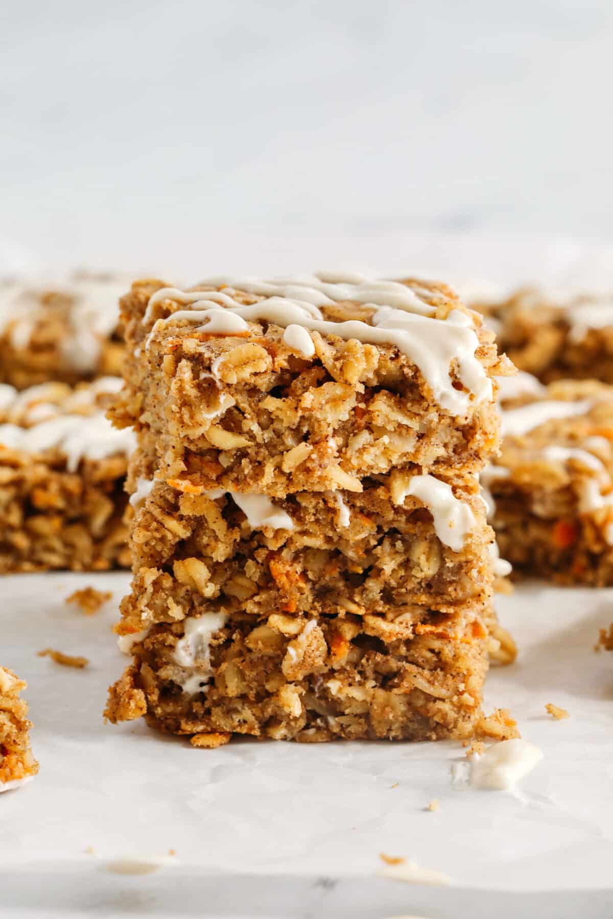 These EASY Healthy Carrot Cake Oatmeal Breakfast Bars make a quick on-the-go breakfast, snack or wholesome dessert! Made with zero refined sugar and drizzled with a delicious maple cream cheese frosting.