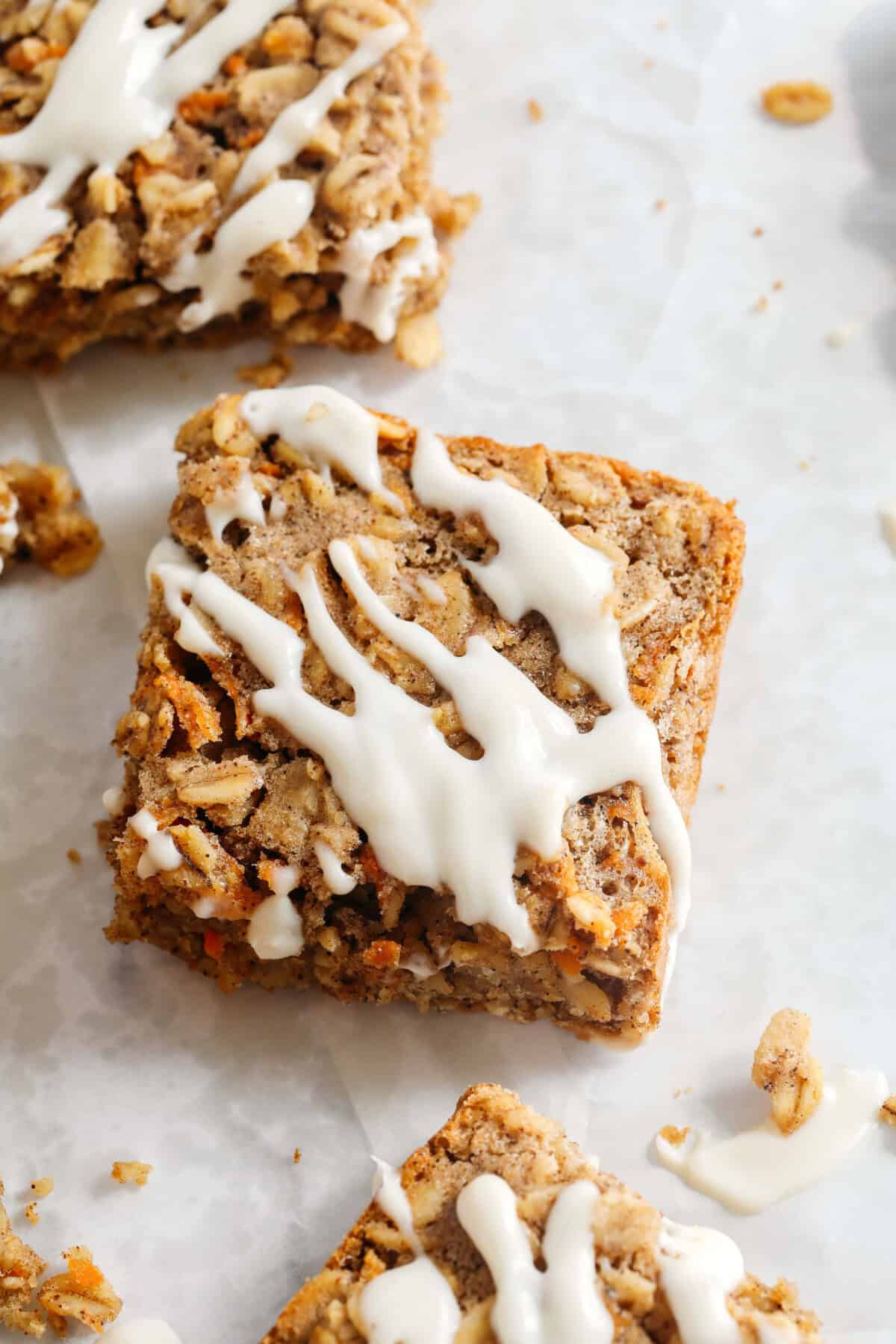 These EASY Healthy Carrot Cake Oatmeal Breakfast Bars make a quick on-the-go breakfast, snack or wholesome dessert! Made with zero refined sugar and drizzled with a delicious maple cream cheese frosting.