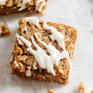 These EASY Healthy Carrot Cake Oatmeal Breakfast Bars make a quick on-the-go breakfast, snack or wholesome dessert! Made with zero refined sugar and drizzled with a delicious maple cream cheese frosting.