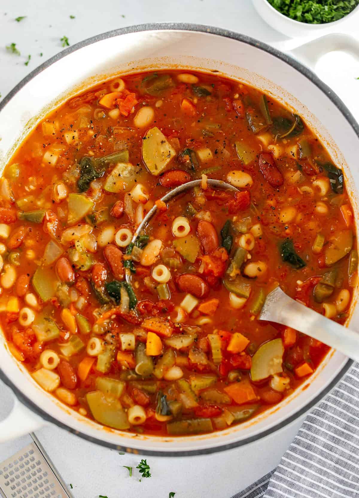 Easy and delicious Olive Garden Minestrone Soup loaded with fresh veggies, leafy greens and simmered in the most flavorful broth! Easily made in one pot for a cozy weeknight dinner the whole family will love!