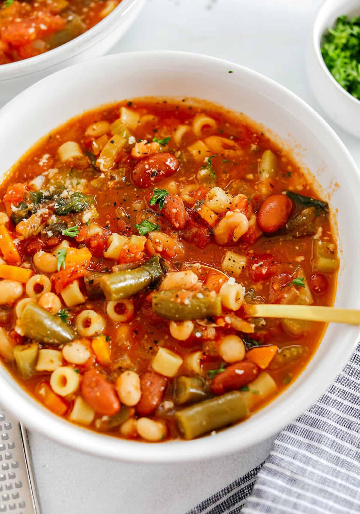 Easy and delicious Olive Garden Minestrone Soup loaded with fresh veggies, leafy greens and simmered in the most flavorful broth! Easily made in one pot for a cozy weeknight dinner the whole family will love!