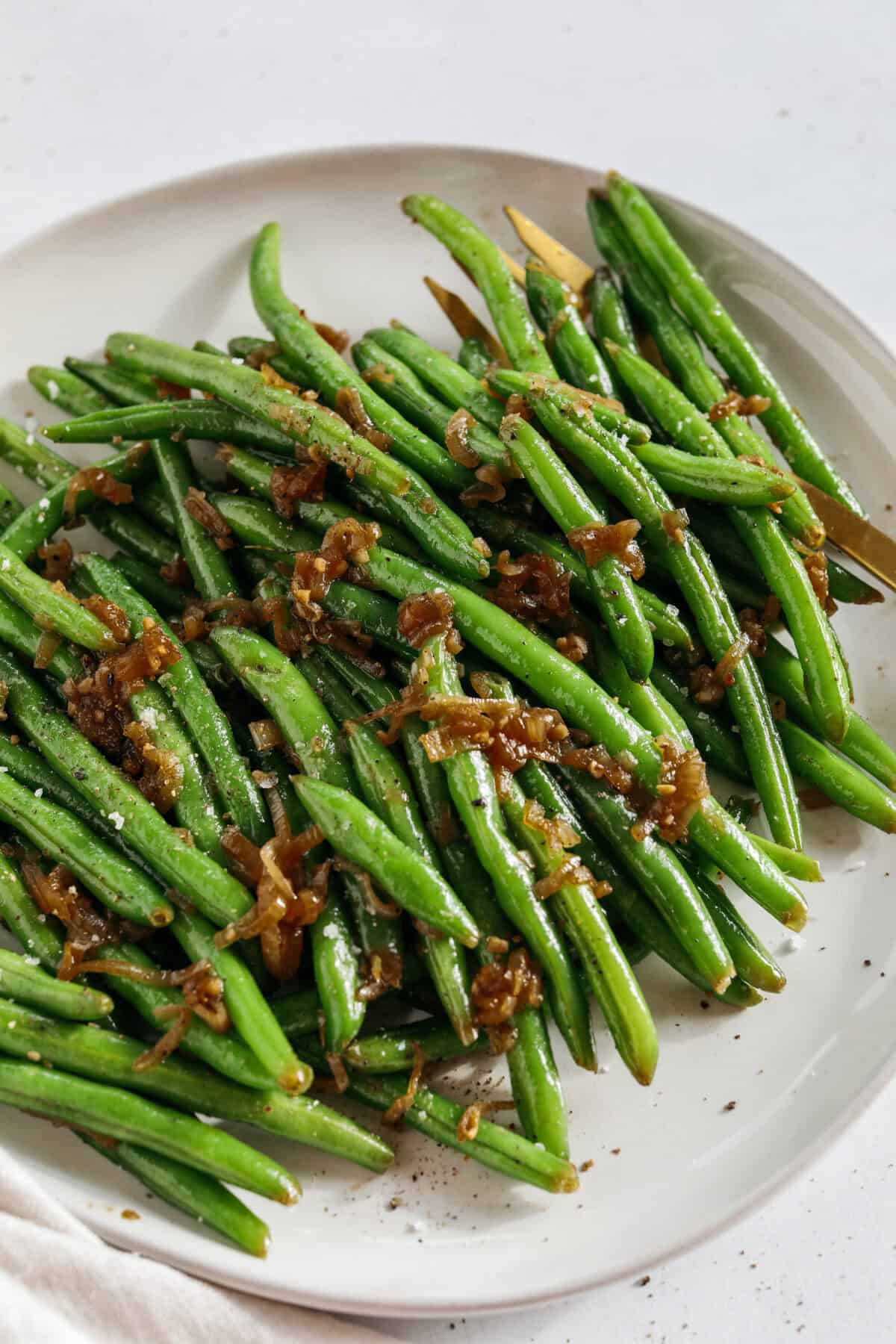 These fresh and crisp Garlicky Green Beans with Caramelized Shallots are a simple, healthy and flavorful side dish that comes together in just 15 minutes! No blanching necessary. Perfect for busy weeknights or served with a holiday meal.
