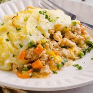Cozy and delicious Healthy Turkey Shepherd's Pie Recipe made with lean ground turkey, colorful vegetables, rich homemade gravy and topped with lighter mashed potatoes. A healthier twist on a classic comfort food dish the whole family will love!