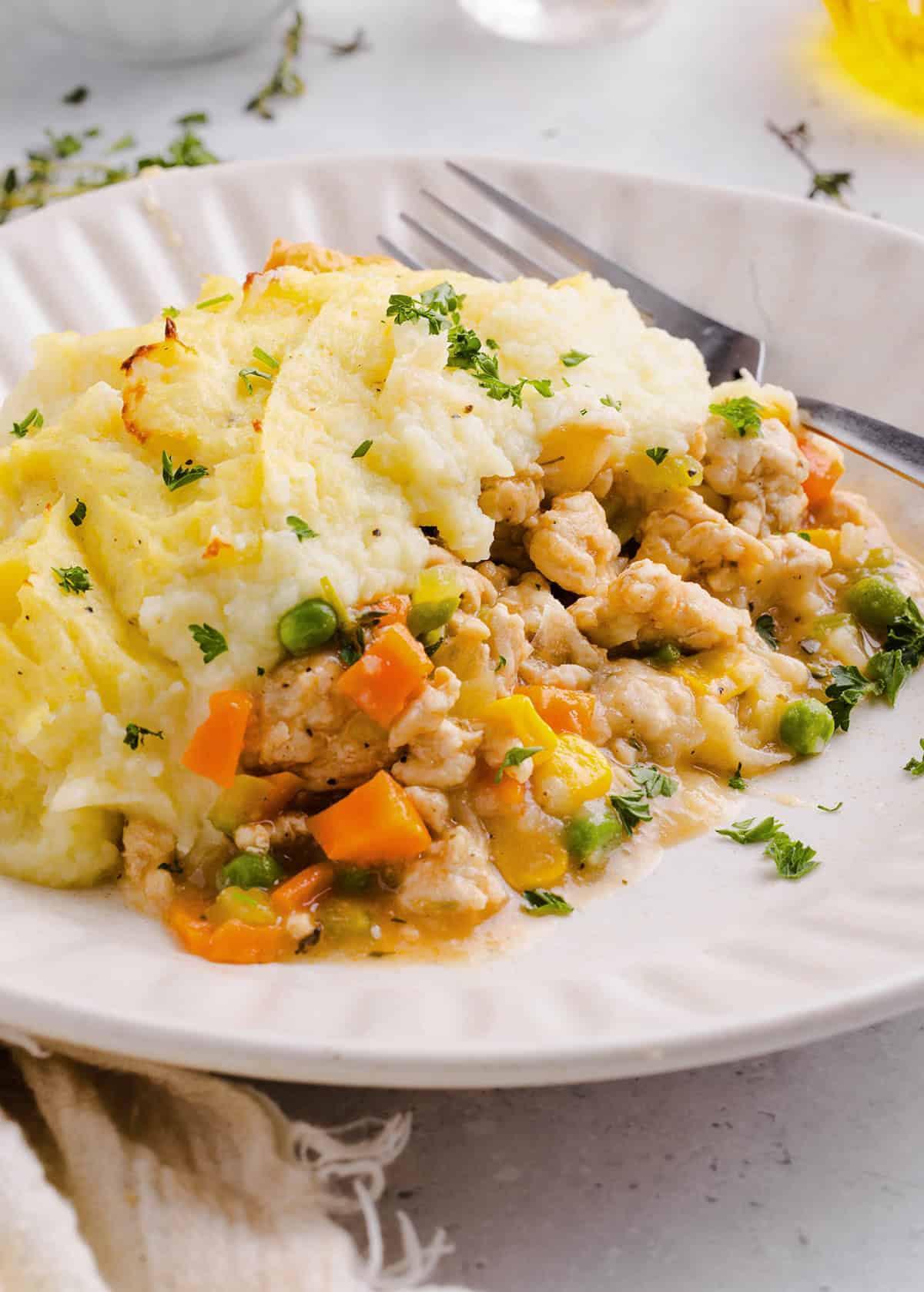 Cozy and delicious Healthy Turkey Shepherd's Pie Recipe made with lean ground turkey, colorful vegetables, rich homemade gravy and topped with lighter mashed potatoes. A healthier twist on a classic comfort food dish the whole family will love!