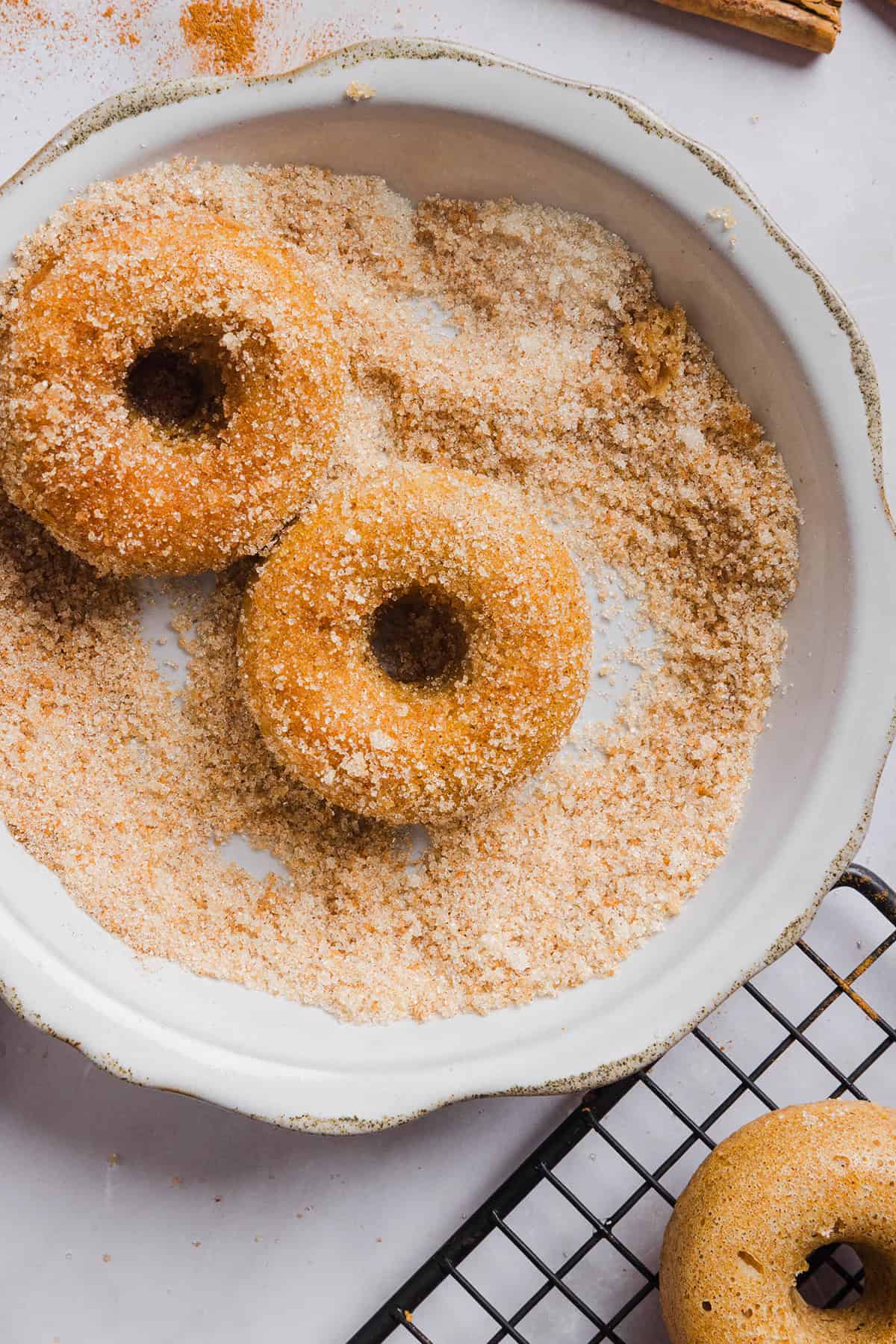 Soft Baked Apple Cider Donuts made healthier with whole wheat flour, applesauce and Greek yogurt for the perfect fall treat that comes together in just 20 minutes!  Loaded with warm spices and coated with cinnamon and sugar!