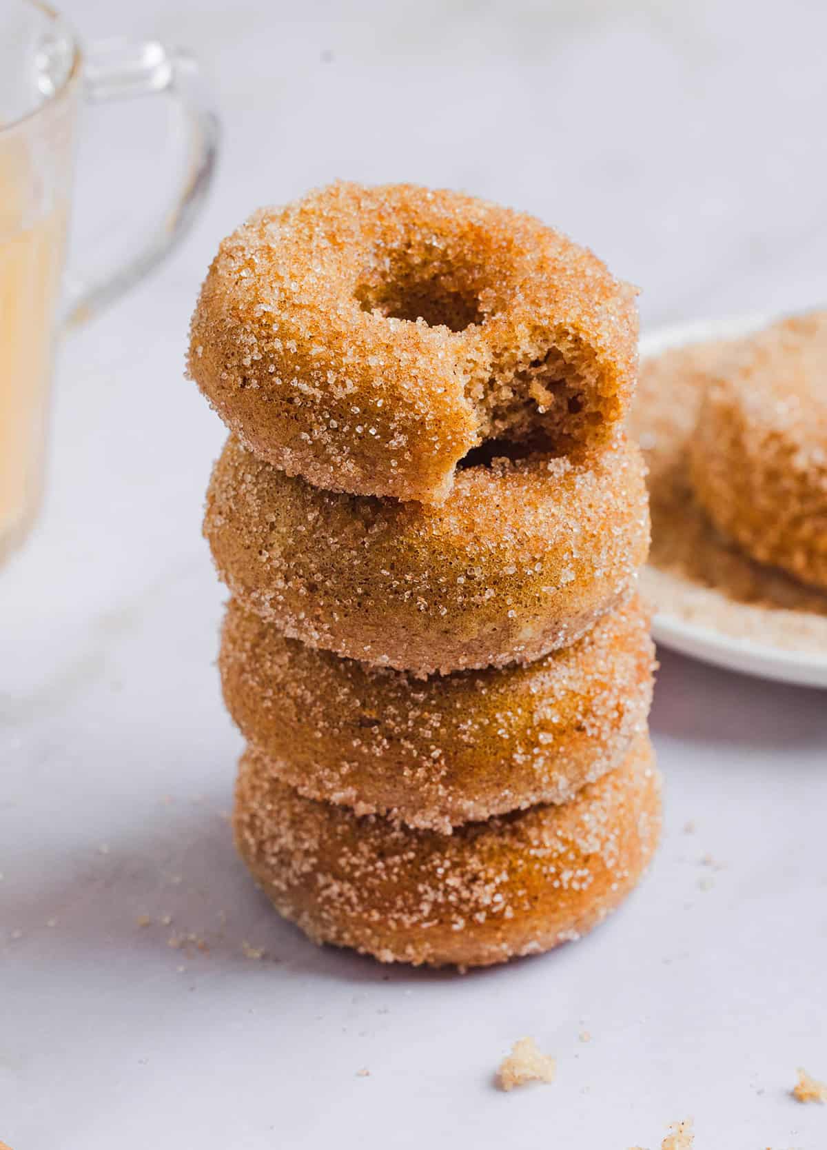 Soft Baked Apple Cider Donuts made healthier with whole wheat flour, applesauce and Greek yogurt for the perfect fall treat that comes together in just 20 minutes!  Loaded with warm spices and coated with cinnamon and sugar!