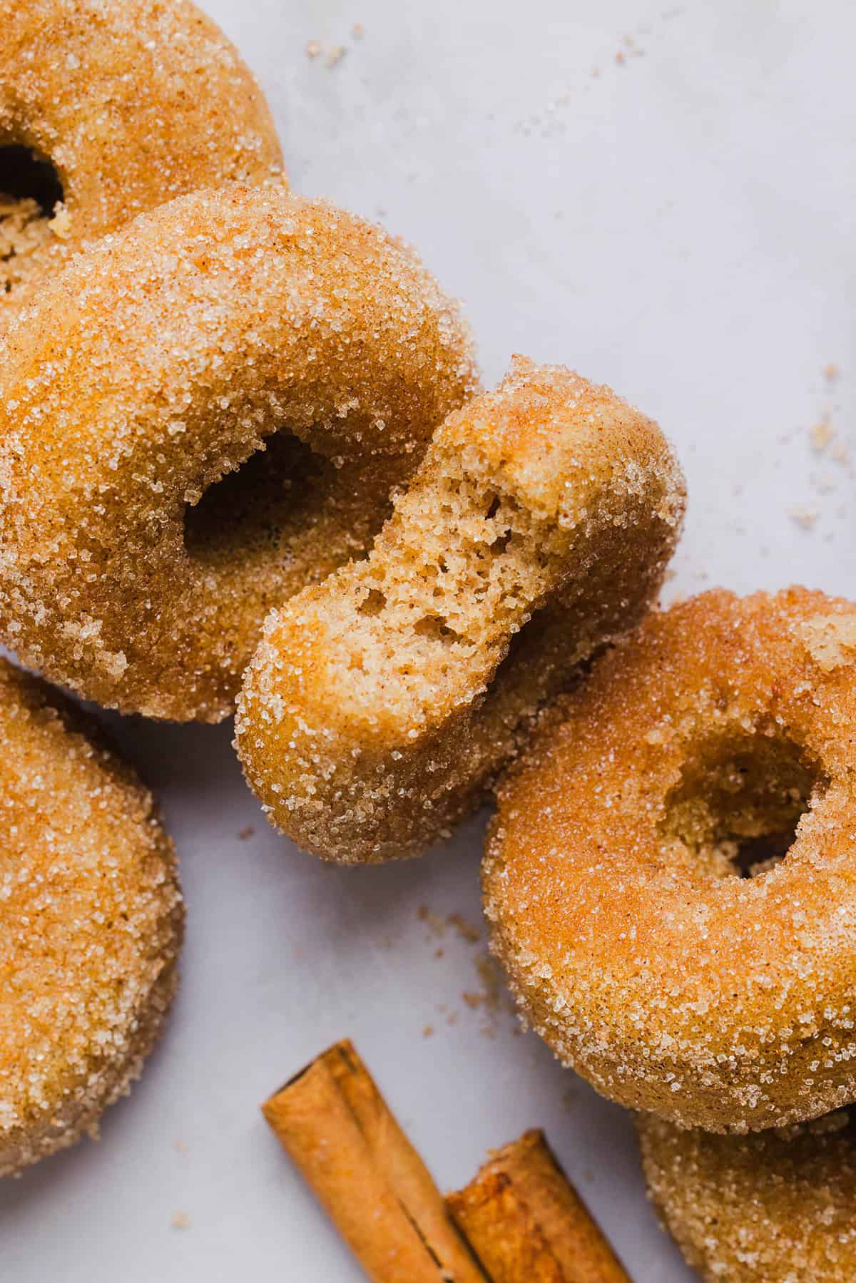 Soft Baked Apple Cider Donuts made healthier with whole wheat flour, applesauce and Greek yogurt for the perfect fall treat that comes together in just 20 minutes!  Loaded with warm spices and coated with cinnamon and sugar!